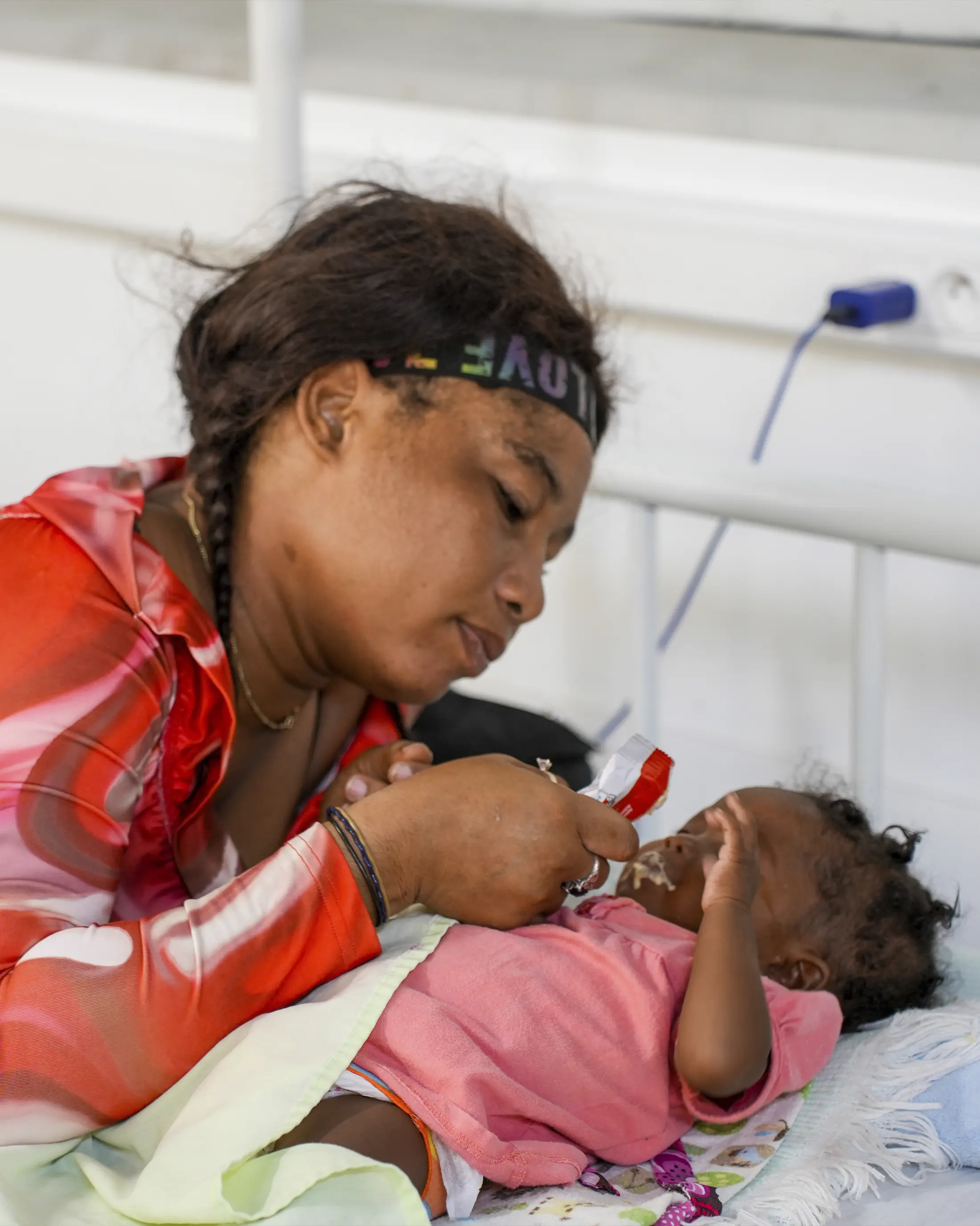 Paciente MSF utilizando un paquete de nutrición con su bebé